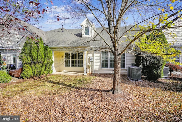 back of property featuring a lawn and central air condition unit