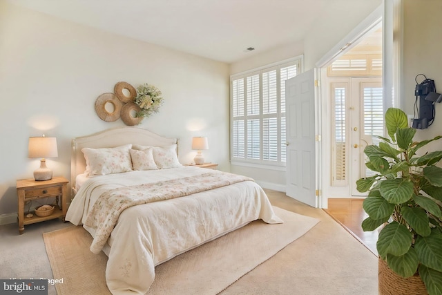 carpeted bedroom with access to exterior and multiple windows