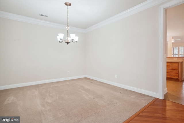 empty room with hardwood / wood-style floors, crown molding, and an inviting chandelier