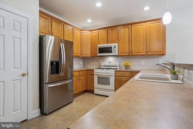 kitchen with white appliances, decorative backsplash, sink, and hanging light fixtures