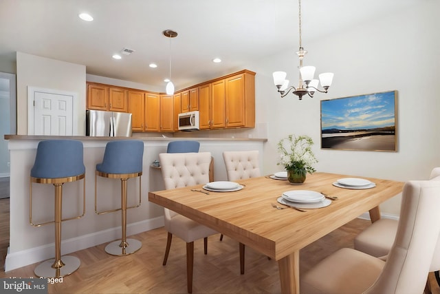 dining area featuring light parquet flooring and a chandelier