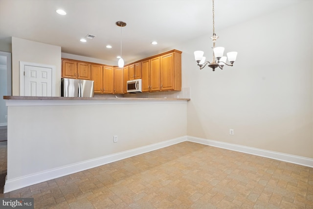 kitchen with stainless steel refrigerator, kitchen peninsula, hanging light fixtures, and an inviting chandelier