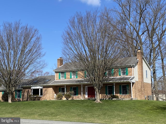 view of front of home with a front yard and cooling unit