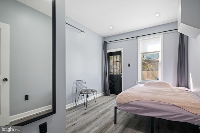 bedroom featuring baseboards, light wood-type flooring, and recessed lighting