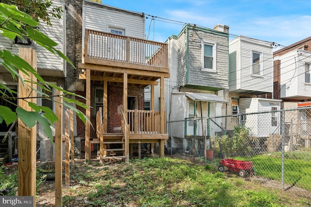 rear view of property featuring a wooden deck