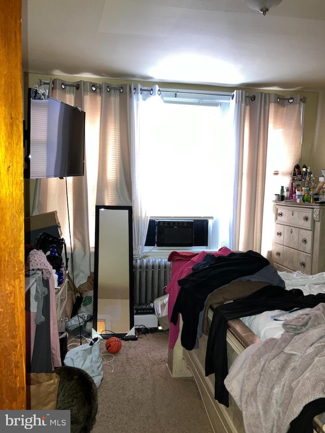 carpeted bedroom featuring cooling unit and radiator heating unit