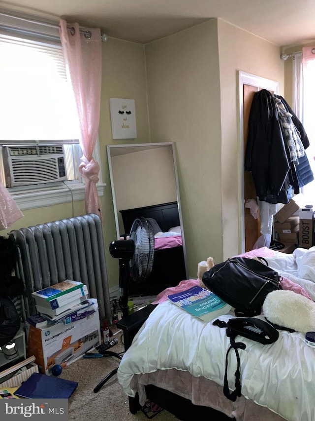 carpeted bedroom featuring cooling unit and radiator heating unit