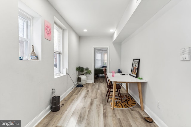 corridor featuring light wood-type flooring and plenty of natural light