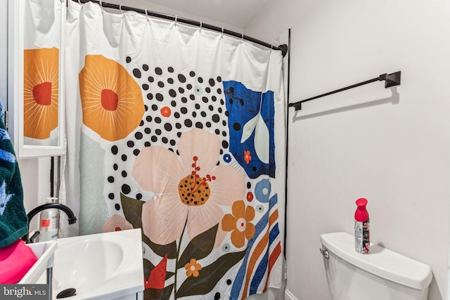 bathroom with curtained shower, vanity, and toilet