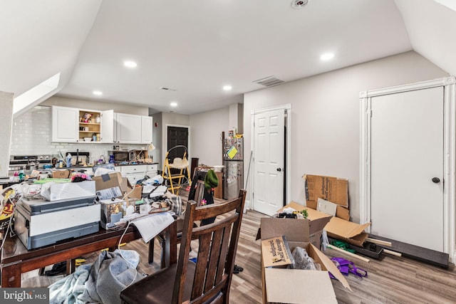 office space featuring lofted ceiling and light hardwood / wood-style floors