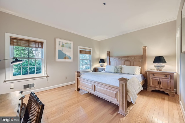 bedroom featuring ornamental molding and light hardwood / wood-style flooring