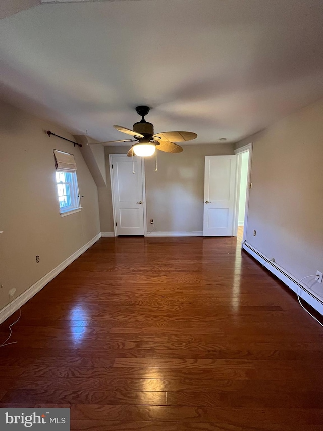 spare room featuring a baseboard heating unit, dark hardwood / wood-style floors, and ceiling fan