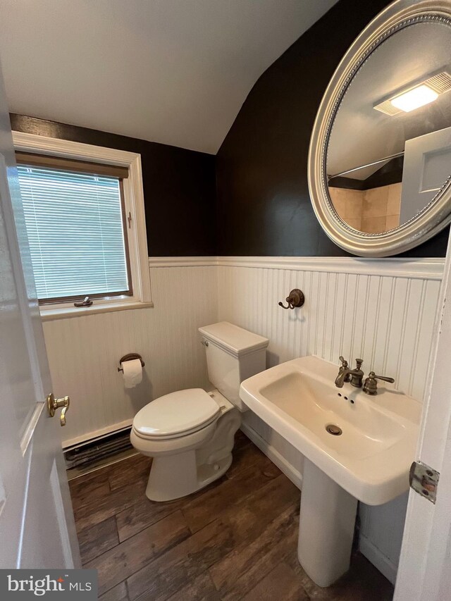 bathroom featuring hardwood / wood-style floors, vaulted ceiling, a baseboard heating unit, and toilet