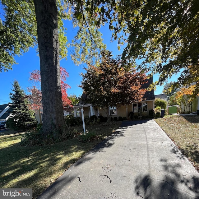 view of property hidden behind natural elements featuring a front lawn