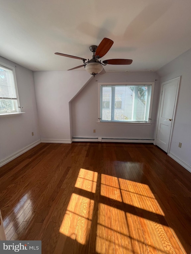 bonus room with baseboard heating, hardwood / wood-style floors, and ceiling fan