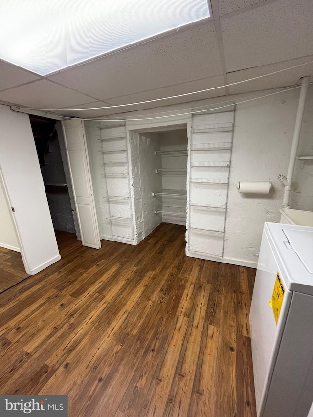 interior space featuring a paneled ceiling, dark hardwood / wood-style floors, a closet, and washer / clothes dryer