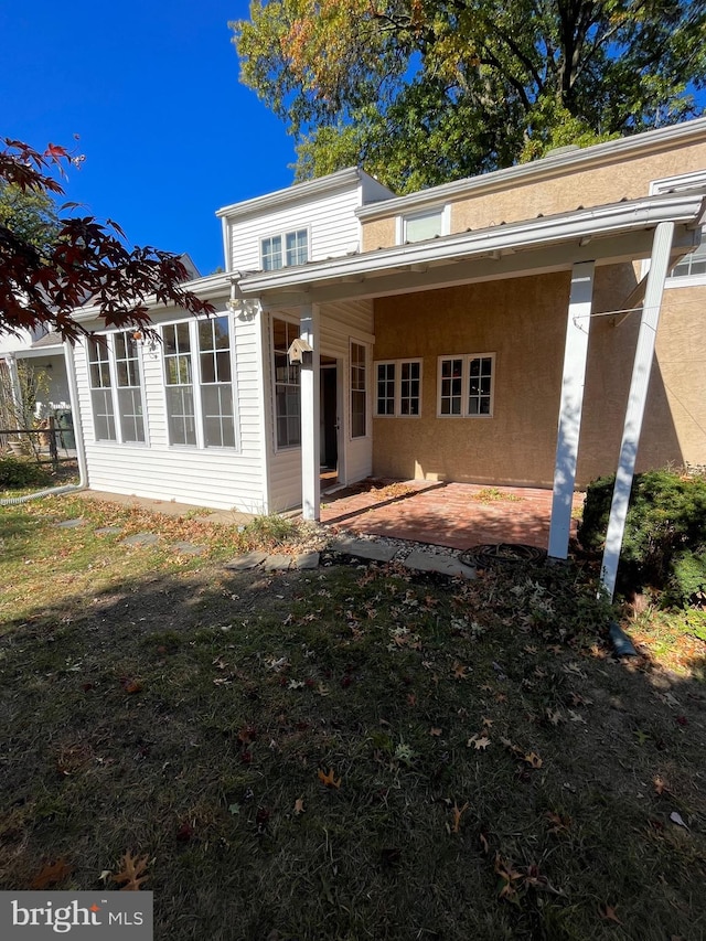 rear view of house with a patio area and a yard