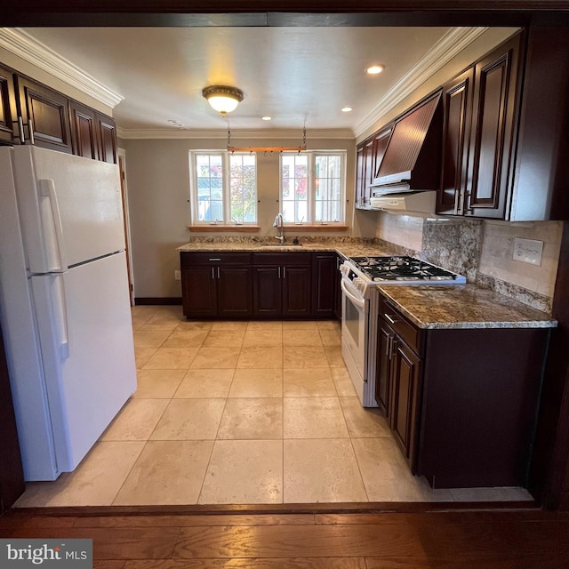 kitchen featuring dark brown cabinets, ornamental molding, sink, custom exhaust hood, and white appliances