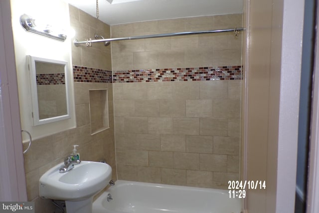 bathroom featuring tile walls, sink, and tiled shower / bath combo