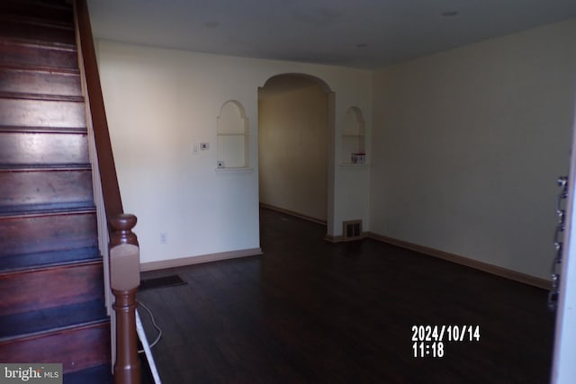 unfurnished room with dark wood-type flooring