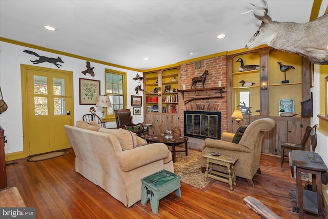 living room with plenty of natural light, ornamental molding, hardwood / wood-style flooring, and a fireplace