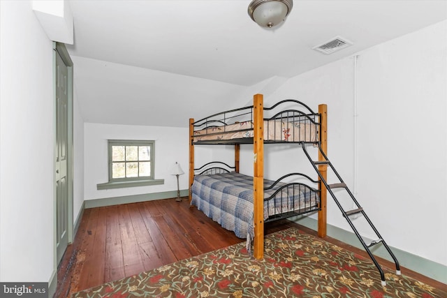 bedroom with lofted ceiling and dark hardwood / wood-style floors