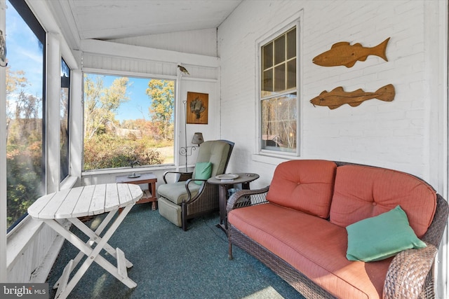 sunroom featuring lofted ceiling and a healthy amount of sunlight