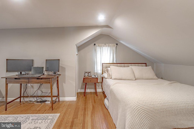 bedroom featuring lofted ceiling and light hardwood / wood-style flooring