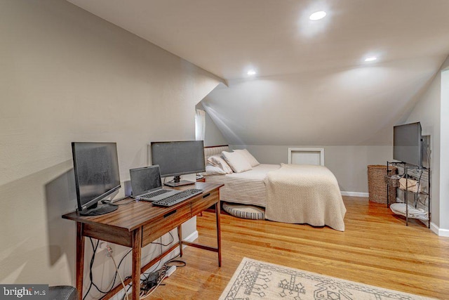 bedroom with light hardwood / wood-style floors and lofted ceiling