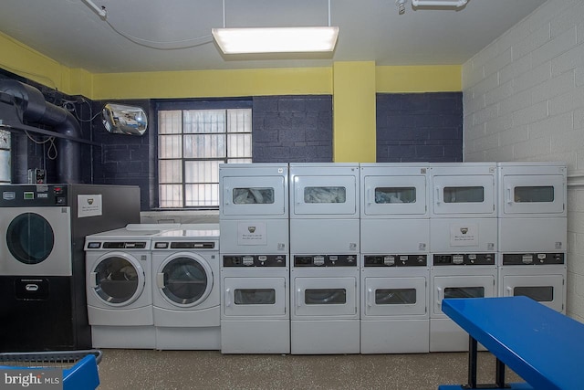 clothes washing area with stacked washer and dryer and washer and dryer