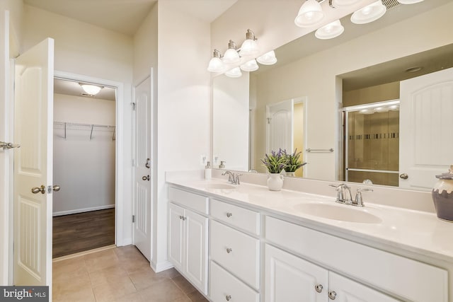 bathroom featuring vanity, an enclosed shower, and tile patterned flooring