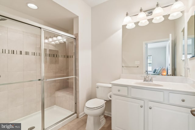 bathroom with toilet, walk in shower, vanity, and tile patterned floors