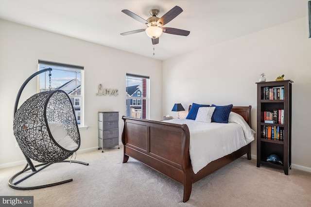 carpeted bedroom featuring multiple windows and ceiling fan