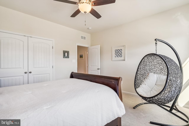 carpeted bedroom featuring a closet and ceiling fan