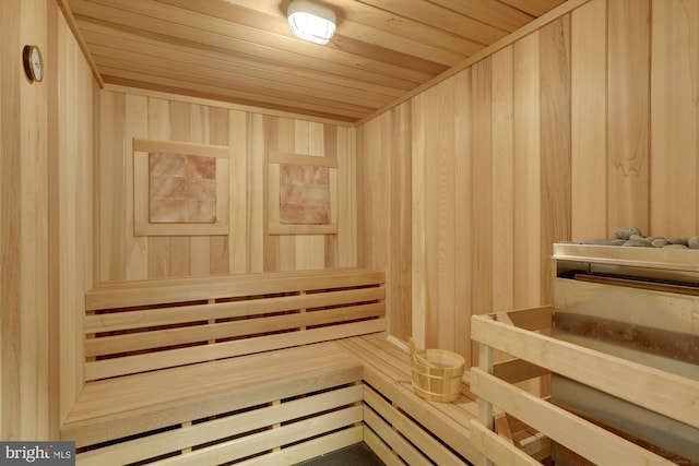 view of sauna featuring wood ceiling and wood walls