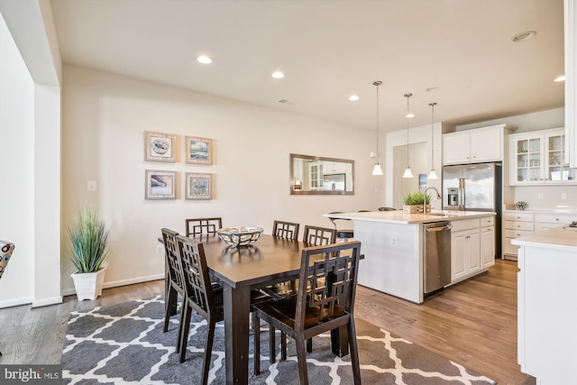 dining room with sink and wood-type flooring