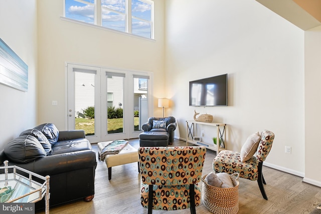 living room featuring a towering ceiling and light wood-type flooring