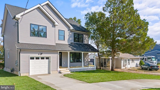 view of front facade with a front yard, a porch, and a garage