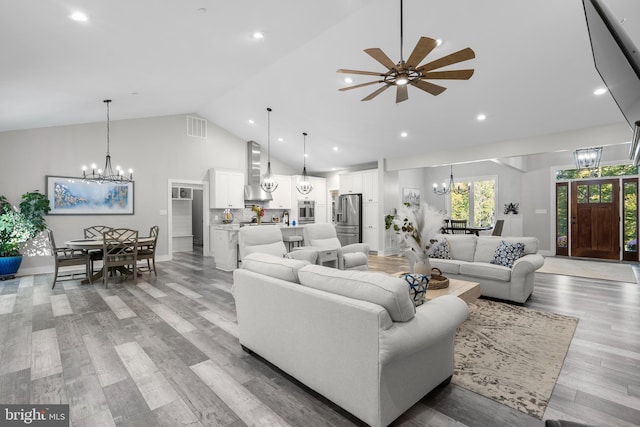 living room featuring light hardwood / wood-style flooring, high vaulted ceiling, and ceiling fan