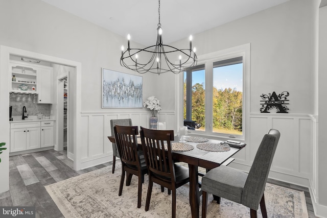 dining area with an inviting chandelier, sink, and dark hardwood / wood-style floors