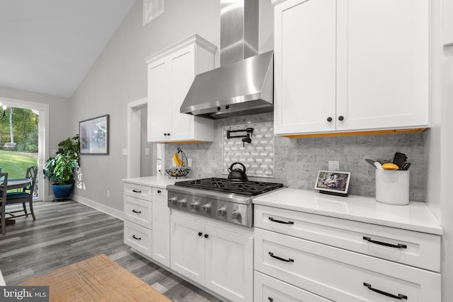 kitchen with white cabinets, tasteful backsplash, dark hardwood / wood-style flooring, stainless steel gas stovetop, and wall chimney exhaust hood