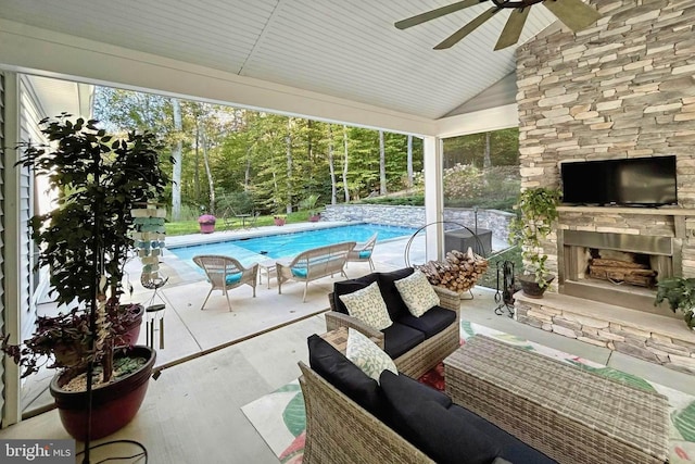 view of pool with ceiling fan, a patio, and an outdoor stone fireplace