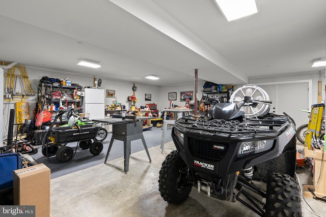 garage with white fridge and a workshop area