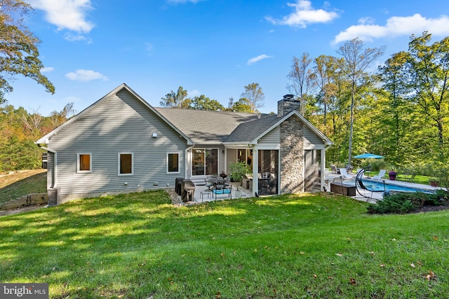 rear view of house featuring a patio area and a yard