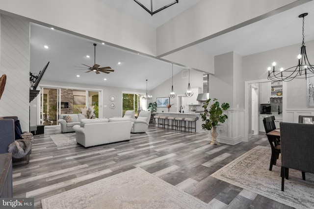 living room with hardwood / wood-style flooring, high vaulted ceiling, and ceiling fan