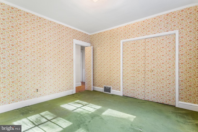 unfurnished bedroom featuring carpet floors, a closet, and crown molding