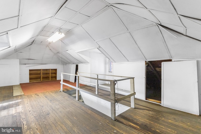 additional living space with dark hardwood / wood-style floors and vaulted ceiling