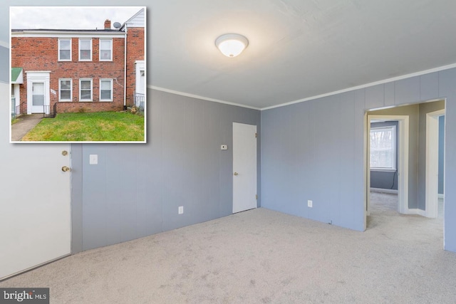 unfurnished room featuring ornamental molding and light colored carpet