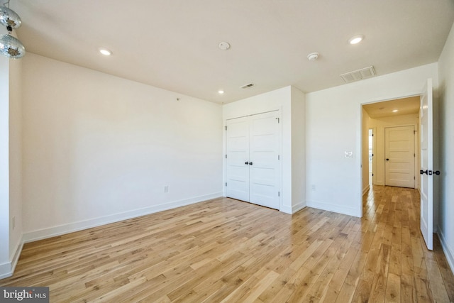 unfurnished bedroom featuring a closet and light wood-type flooring