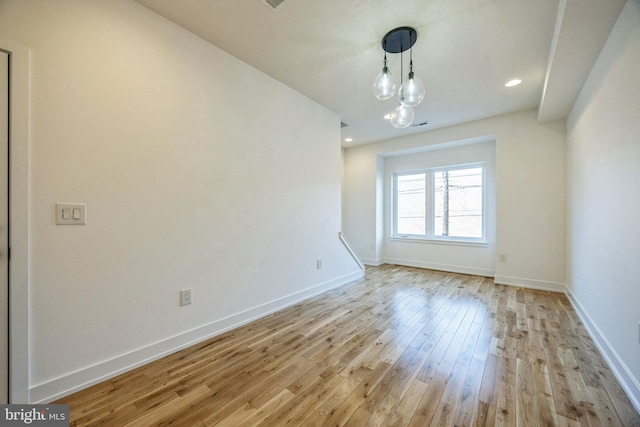 unfurnished dining area featuring a notable chandelier and light wood-type flooring